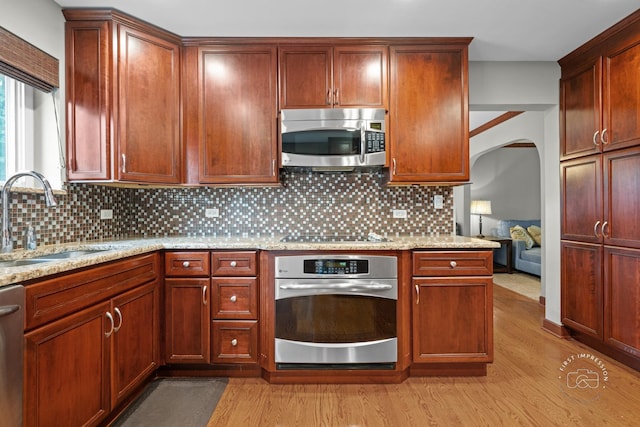 502 Burning Tree Ln, Naperville, IL 60563 - kitchen with appliances with stainless steel finishes, light wood finished floors, decorative backsplash, and light stone counters