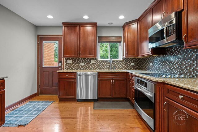 502 Burning Tree Ln, Naperville, IL 60563 - kitchen featuring appliances with stainless steel finishes, decorative backsplash, light stone countertops, light wood-style flooring, and recessed lighting