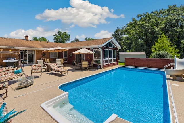 1934 Philip Dr, Dixon, IL 61021 - swimming pool featuring a water slide, a patio area, and a sunroom
