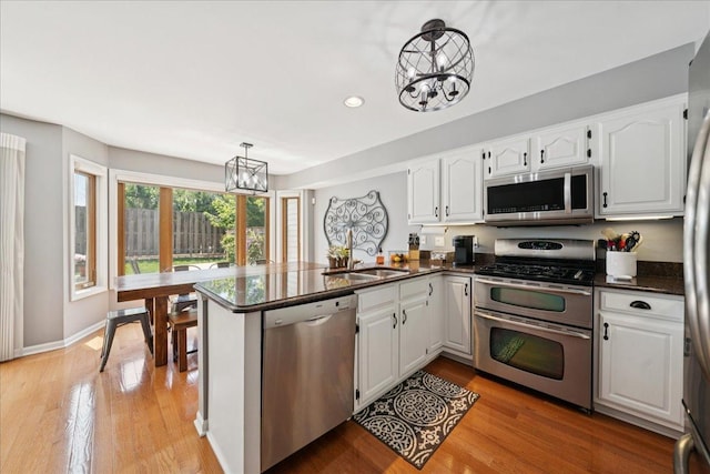 237 Carlisle Ave, Westmont, IL 60559 - kitchen with appliances with stainless steel finishes, a chandelier, a peninsula, white cabinets, and recessed lighting
