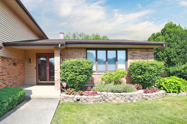 740 Ruskin Dr, Elk Grove Village, IL 60007 - doorway to property featuring brick siding, a yard, and a chimney