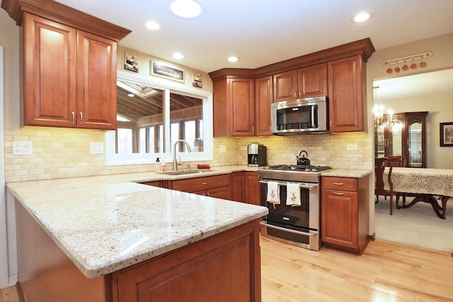 740 Ruskin Dr, Elk Grove Village, IL 60007 - kitchen with appliances with stainless steel finishes, light stone countertops, light wood finished floors, a peninsula, and recessed lighting