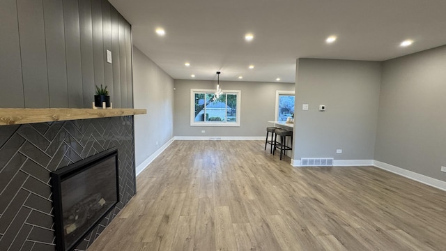 626 E 194th St, Glenwood, IL 60425 - unfurnished living room featuring light wood-style flooring, a glass covered fireplace, and recessed lighting