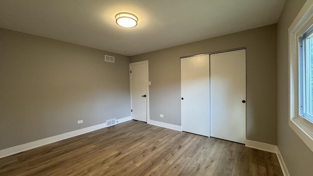 626 E 194th St, Glenwood, IL 60425 - unfurnished bedroom featuring wood finished floors, a closet, and multiple windows
