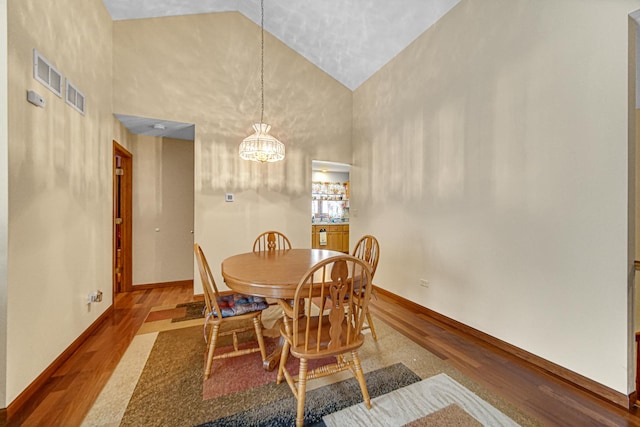 2718 Lake Side Cir, Joliet, IL 60431 - dining space featuring wood finished floors, a chandelier, and high vaulted ceiling