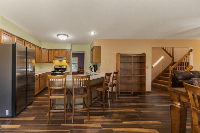 2805 Polo Rd, Bloomington, IL 61704 - kitchen with stainless steel appliances, wood finish floors, brown cabinets, under cabinet range hood, and recessed lighting