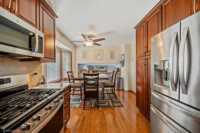 16206 Everdon Dr, Tinley Park, IL 60477 - kitchen featuring stainless steel appliances, decorative backsplash, a ceiling fan, light wood finished floors, and brown cabinetry