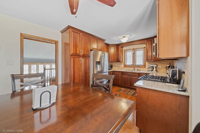 16206 Everdon Dr, Tinley Park, IL 60477 - kitchen featuring stainless steel fridge with ice dispenser, tasteful backsplash, a ceiling fan, brown cabinets, and light stone countertops