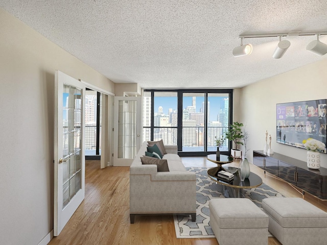 10 E Ontario St Unit 3912, Chicago, IL 60611 - living room featuring a textured ceiling, healthy amount of natural light, wood finished floors, track lighting, and expansive windows