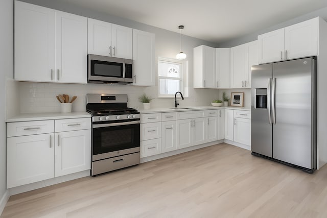 1428 N Central Ave, Chicago, IL 60651 - kitchen with stainless steel appliances, light wood-type flooring, and white cabinets
