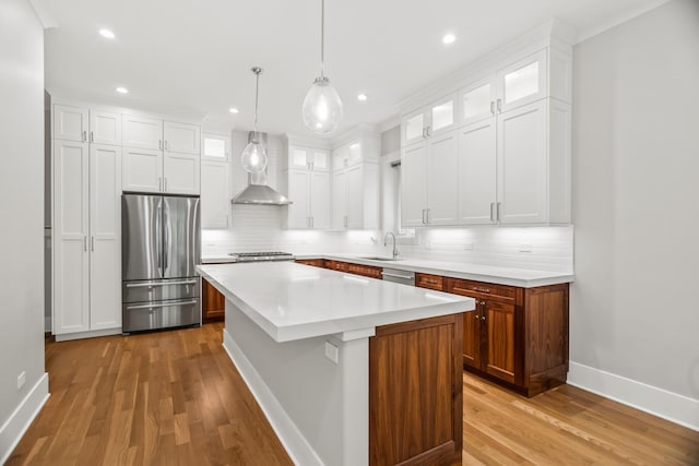 4133 N Kenmore Ave Unit 1N, Chicago, IL 60613 - kitchen featuring appliances with stainless steel finishes, wall chimney exhaust hood, tasteful backsplash, light wood-style flooring, and recessed lighting