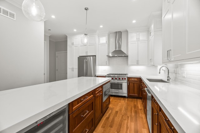 4133 N Kenmore Ave Unit 1N, Chicago, IL 60613 - kitchen with wall chimney range hood, stainless steel appliances, white cabinets, crown molding, and tasteful backsplash