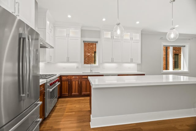 4133 N Kenmore Ave Unit 1N, Chicago, IL 60613 - kitchen featuring stainless steel appliances, light countertops, crown molding, dark wood-style flooring, and glass insert cabinets