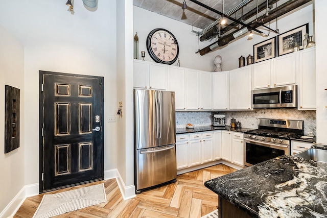 1820 N Spaulding Ave Unit 102, Chicago, IL 60647 - kitchen featuring appliances with stainless steel finishes, a high ceiling, decorative backsplash, white cabinetry, and dark stone counters