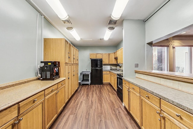 3843 Appian Way, Glenview, IL 60025 - kitchen featuring wood finished floors, black appliances, and light countertops