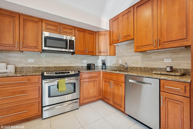 3843 Appian Way, Glenview, IL 60025 - kitchen featuring appliances with stainless steel finishes, brown cabinetry, light stone countertops, and decorative backsplash