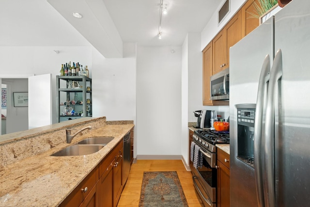 1201 S Prairie Ave Unit 5004, Chicago, IL 60605 - kitchen featuring stainless steel appliances, light wood-style floors, light stone countertops, brown cabinets, and a peninsula