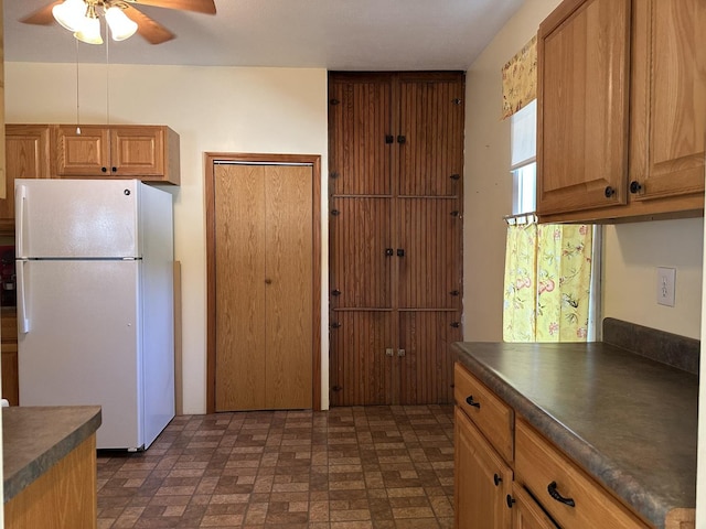 12851 Argo Fay Rd, Thomson, IL 61285 - kitchen featuring freestanding refrigerator, dark countertops, a ceiling fan, and brick patterned floors