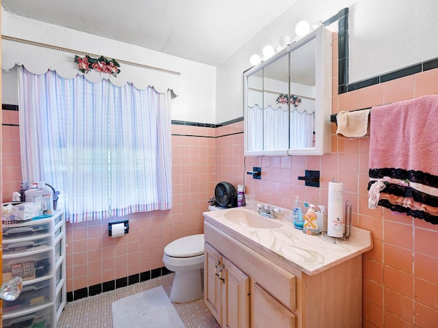 10458 S Forest Ave, Chicago, IL 60628 - bathroom featuring tile walls, vanity, tile patterned floors, healthy amount of natural light, and a wainscoted wall