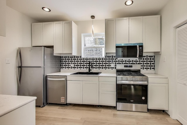 7716 S Rhodes Ave, Chicago, IL 60619 - kitchen with stainless steel appliances, light countertops, backsplash, hanging light fixtures, and recessed lighting