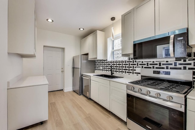 7716 S Rhodes Ave, Chicago, IL 60619 - kitchen with appliances with stainless steel finishes, light countertops, tasteful backsplash, light wood-type flooring, and pendant lighting
