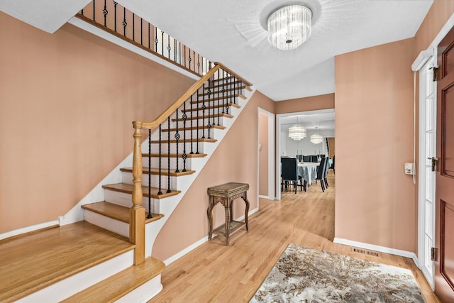 49 Red Oak Ln, Highland Park, IL 60035 - foyer entrance featuring a chandelier, stairs, and wood finished floors