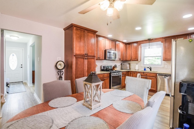 1021 Otis Ave, Rockdale, IL 60436 - kitchen featuring appliances with stainless steel finishes, light wood-style floors, ceiling fan, decorative backsplash, and light countertops