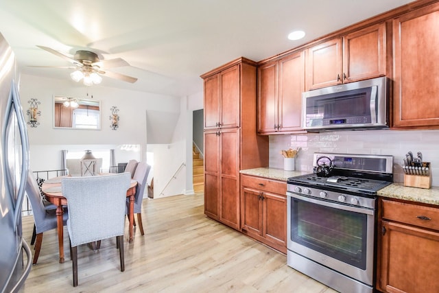 1021 Otis Ave, Rockdale, IL 60436 - kitchen featuring appliances with stainless steel finishes, light wood-type flooring, a ceiling fan, backsplash, and brown cabinetry