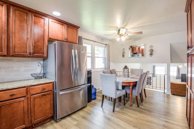 1021 Otis Ave, Rockdale, IL 60436 - kitchen featuring freestanding refrigerator, light wood-type flooring, ceiling fan, backsplash, and brown cabinets