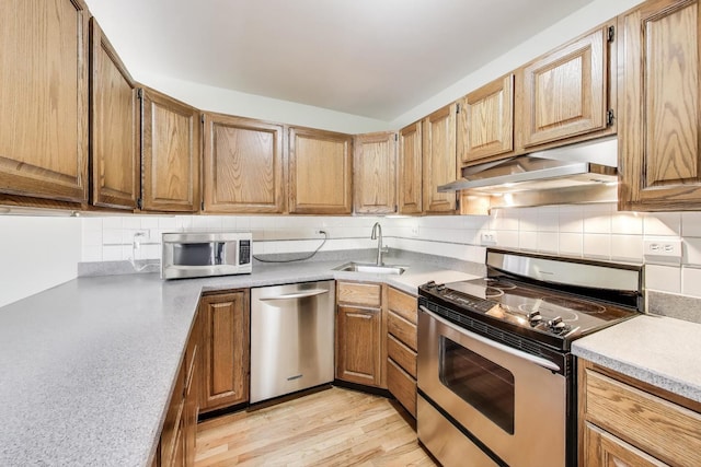 108 Bishop Quarter Ln, Oak Park, IL 60302 - kitchen with appliances with stainless steel finishes, under cabinet range hood, light countertops, decorative backsplash, and light wood finished floors
