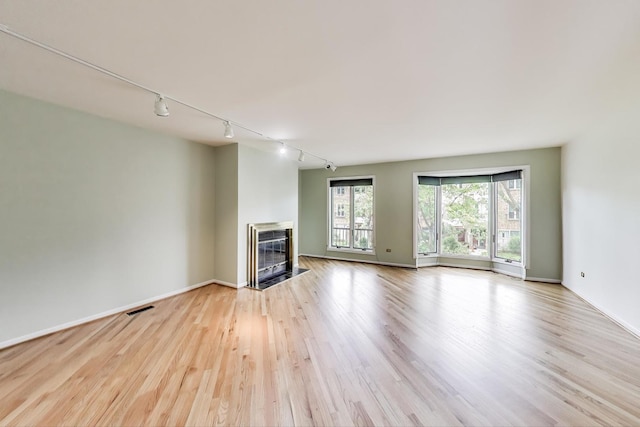 108 Bishop Quarter Ln, Oak Park, IL 60302 - unfurnished living room featuring track lighting, a fireplace with flush hearth, wood finished floors, and heating unit