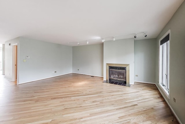 108 Bishop Quarter Ln, Oak Park, IL 60302 - unfurnished living room with track lighting, light wood-type flooring, a fireplace with flush hearth, and plenty of natural light