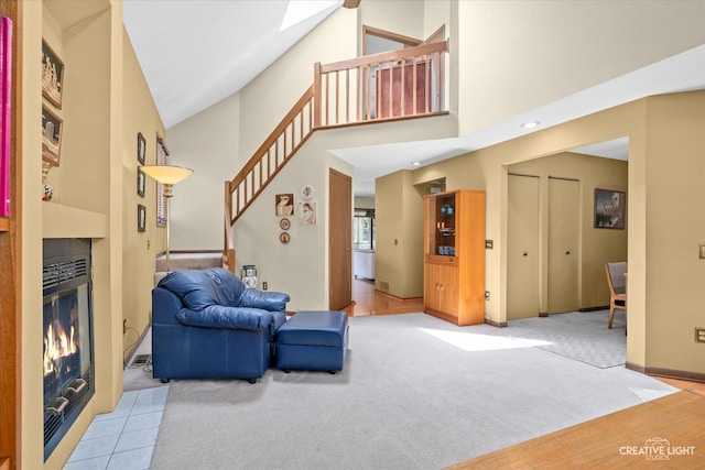 872 Shady Ln, Aurora, IL 60506 - carpeted living area featuring a tiled fireplace, stairway, and a towering ceiling