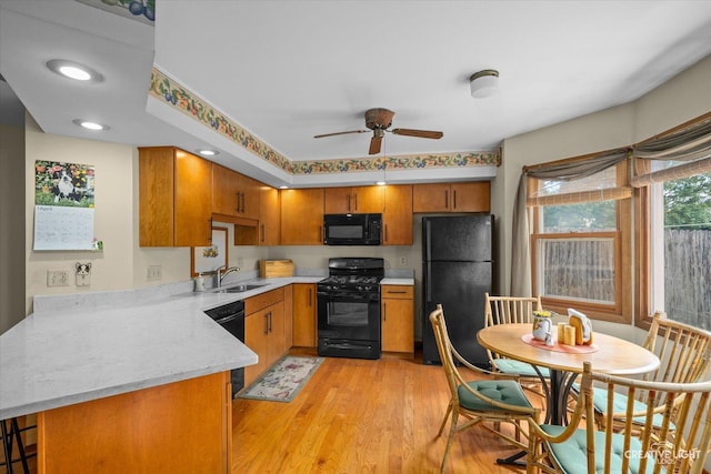 872 Shady Ln, Aurora, IL 60506 - kitchen featuring black appliances, ceiling fan, brown cabinets, light wood-style floors, and a peninsula