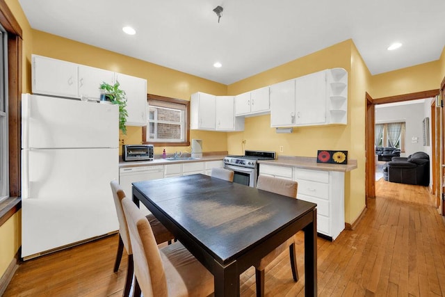 3408 W Marquette Rd, Chicago, IL 60629 - kitchen with freestanding refrigerator, gas stove, white cabinets, light wood-type flooring, and recessed lighting