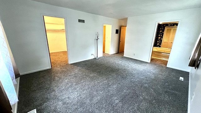 16179 Greenland Dr, Morrison, IL 61270 - unfurnished bedroom with a spacious closet, dark carpet, and ensuite bathroom