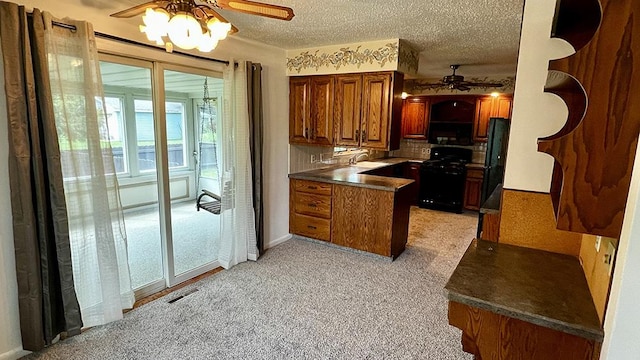 16179 Greenland Dr, Morrison, IL 61270 - kitchen with a ceiling fan, black appliances, a peninsula, brown cabinets, and light colored carpet