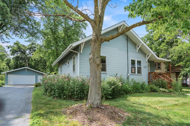 144 Greenley St, Woodstock, IL 60098 - view of property exterior featuring an outdoor structure, a detached garage, and a yard