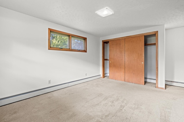 144 Greenley St, Woodstock, IL 60098 - unfurnished bedroom with a baseboard heating unit, light carpet, a closet, and a textured ceiling