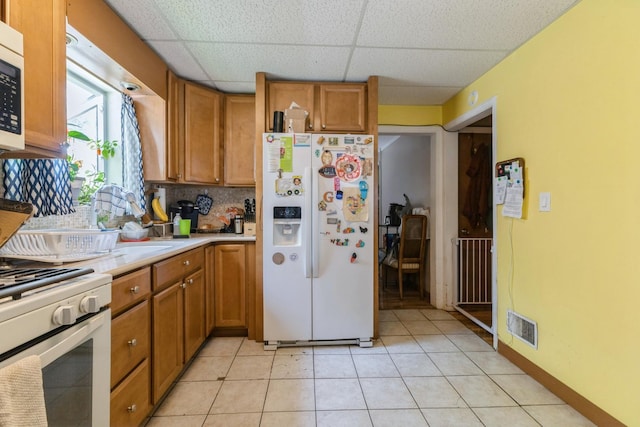 22427 Ridgeway Ave, Richton Park, IL 60471 - kitchen with white appliances, brown cabinetry, light countertops, a drop ceiling, and tasteful backsplash