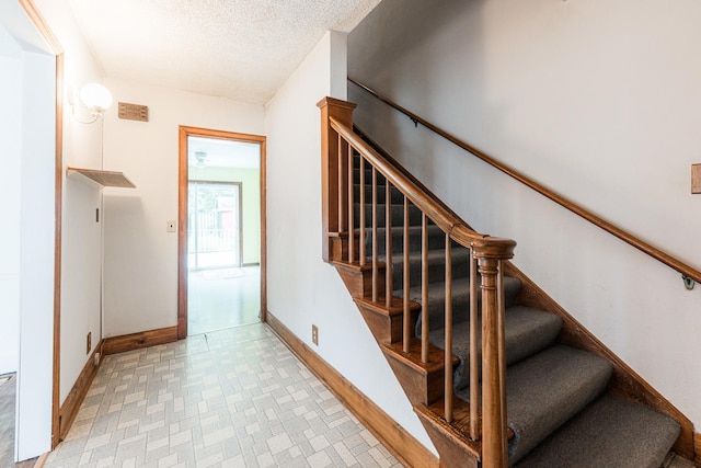 536 Center Ave, Sycamore, IL 60178 - staircase featuring a textured ceiling and tile patterned floors