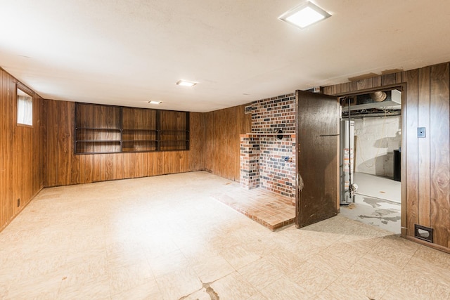 536 Center Ave, Sycamore, IL 60178 - below grade area with wood walls, water heater, tile patterned floors, and a brick fireplace