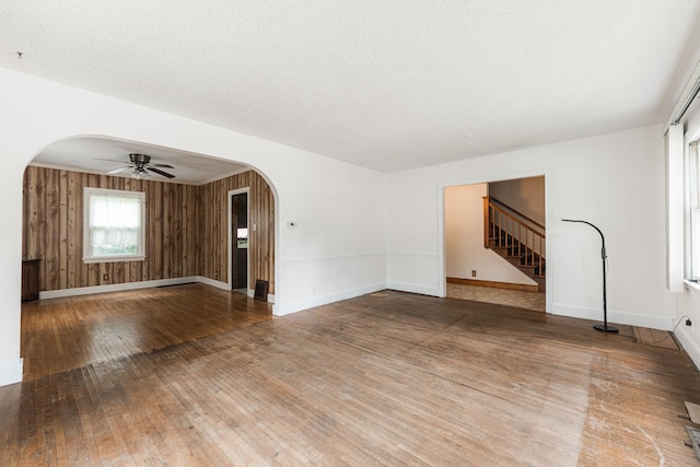 536 Center Ave, Sycamore, IL 60178 - unfurnished living room featuring arched walkways, a ceiling fan, hardwood / wood-style flooring, and stairway
