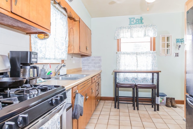 204 N Elroy Ave, Bartlett, IL 60103 - kitchen with stainless steel gas stove, decorative backsplash, light tile patterned floors, and light countertops
