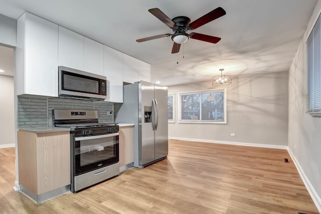 335 Farragut St, Park Forest, IL 60466 - kitchen with stainless steel appliances, light countertops, light wood-style flooring, decorative backsplash, and white cabinets