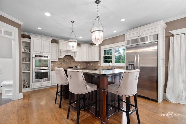 3704 Heathmoor Dr, Elgin, IL 60124 - kitchen featuring stainless steel appliances, white cabinets, crown molding, a kitchen bar, and a kitchen island