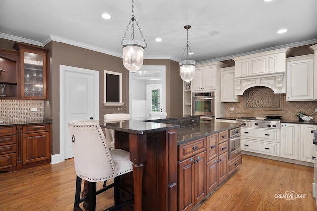 3704 Heathmoor Dr, Elgin, IL 60124 - kitchen featuring appliances with stainless steel finishes, a center island, light wood-style floors, backsplash, and a breakfast bar