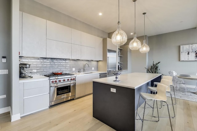 2405 W Iowa St Unit 405, Chicago, IL 60622 - kitchen featuring high end appliances, light wood finished floors, a kitchen bar, backsplash, and recessed lighting