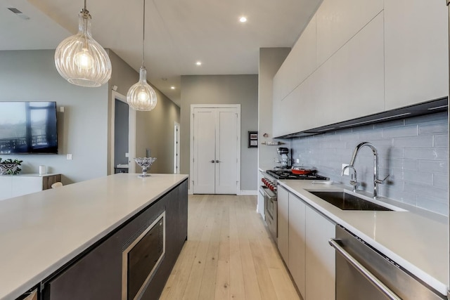 2405 W Iowa St Unit 405, Chicago, IL 60622 - kitchen featuring stainless steel appliances, light countertops, backsplash, modern cabinets, and decorative light fixtures