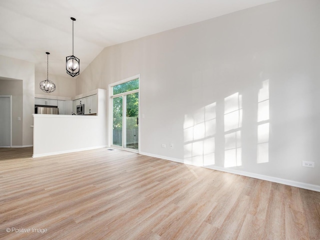 2804 River Bend Ln, Plainfield, IL 60586 - unfurnished living room with light wood-type flooring, a chandelier, and high vaulted ceiling